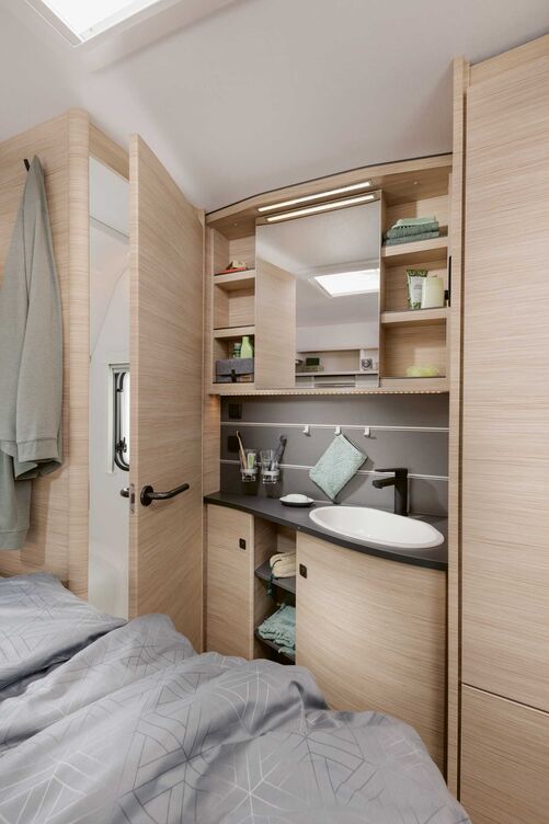 Geschlossener Toilettenraum kombiniert mit offener Waschecke.