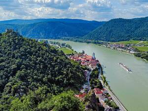 Le décor de carte postale de la Wachau près de Dürnstein, avec son fameux clocher bleu et les ruines de son château fort perché sur un rocher, le tout face au Danube sur lequel navigue paisiblement un bateau de croisière.