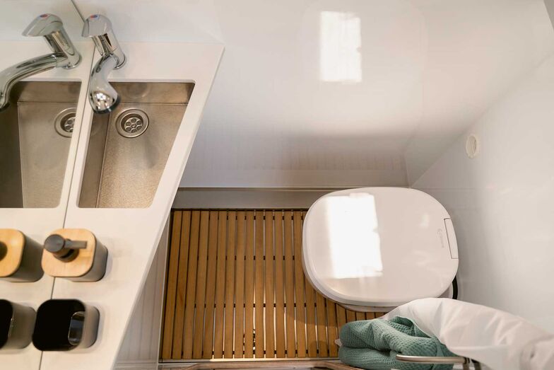 Gegenüber dem Küchenblock: Kompaktes Badezimmer mit Clesana-Toilette.