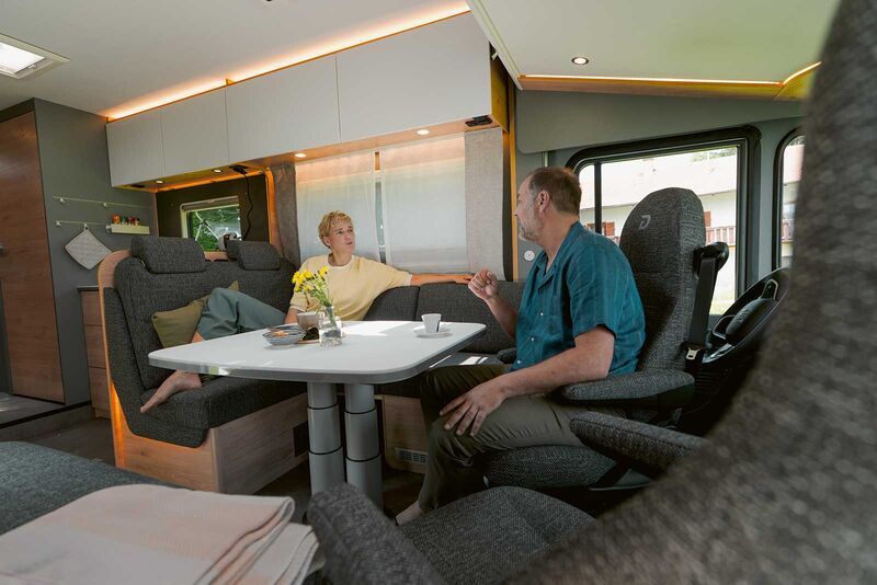 Die grosse l-förmige Sitzgruppe bietet mit der Sitzbank rechts im Fahrzeug und den drehbaren Cockpitsesseln ein grosses Wohnzimmer.