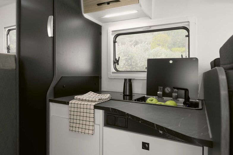 Küchenblock mit zweiflammigem Kocher und Spüle.