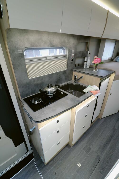 Die Küche im Neo Black Line punktet mit toller Optik und erhöhter Arbeitsfläche über dem 84-l-Kompressorkühlschrank.